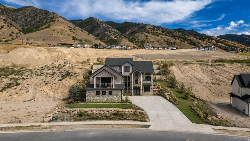 Contemporary exterior featuring stone and siding finishes, a multi-pane glass entry, and an integrated two-car garage