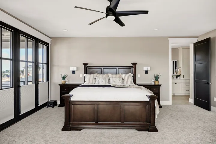 Expansive room featuring multi-panel windows, a ceiling fan, and sconce lighting