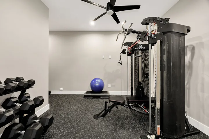 Neutral painted walls, ceiling fan, recessed lighting, and textured flooring