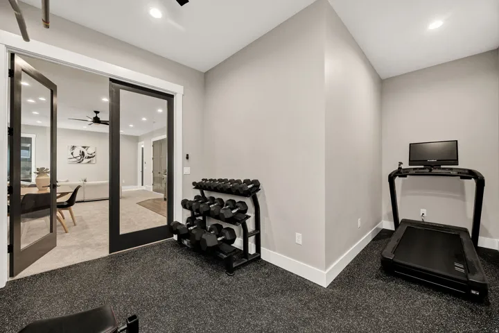Black rubberized flooring, recessed lighting, and a neutral wall color