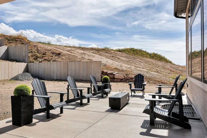 Concrete patio with a built-in outdoor fire pit and a tiered retaining wall