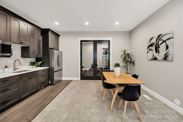 Kitchenette featuring dark wood cabinetry, stainless steel appliances, and a white countertop