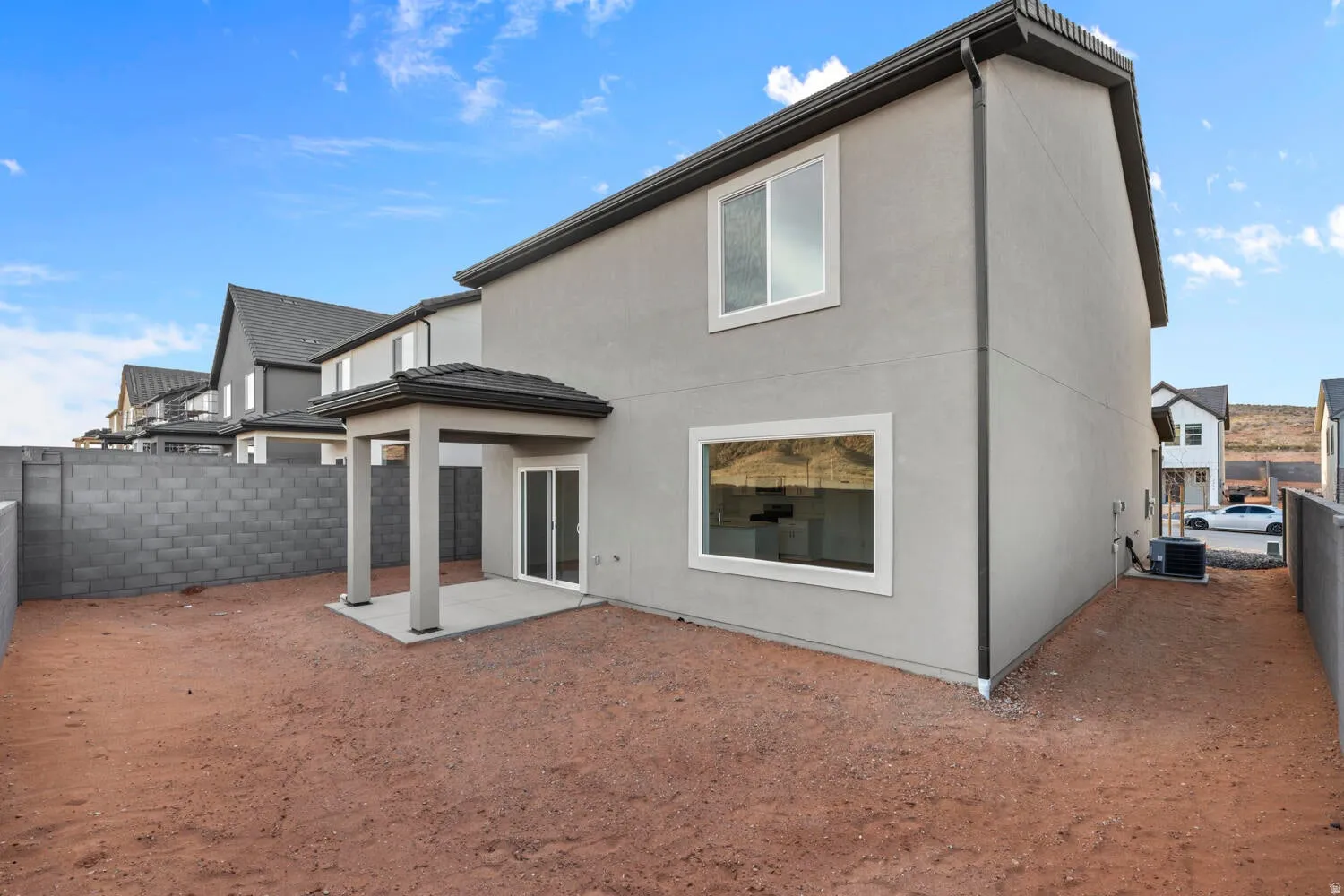 Rear exterior featuring a covered patio with columns and a sliding glass door
