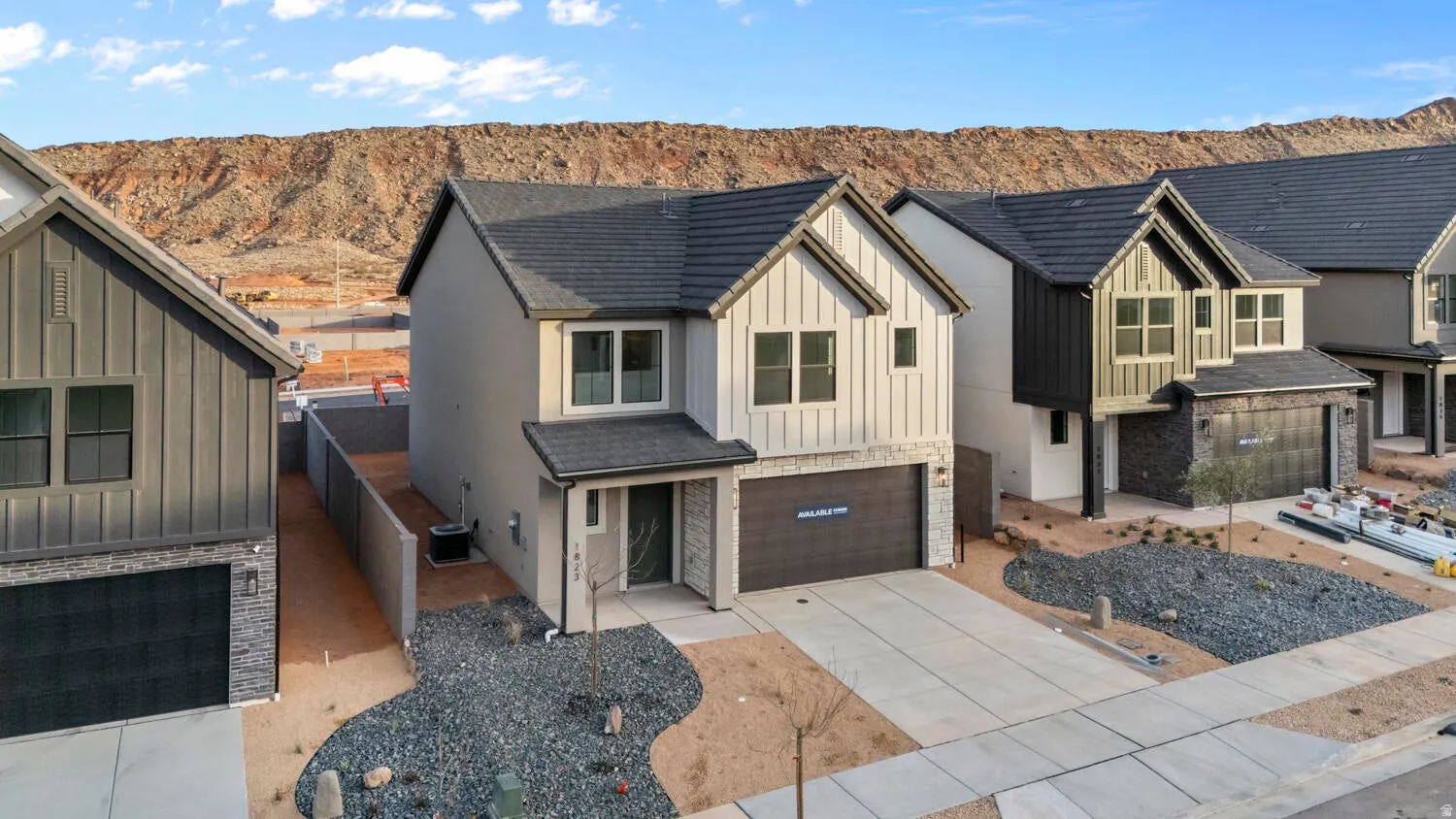 Contemporary exterior with a two-car garage, stone accent siding, and a gravel and rock front yard