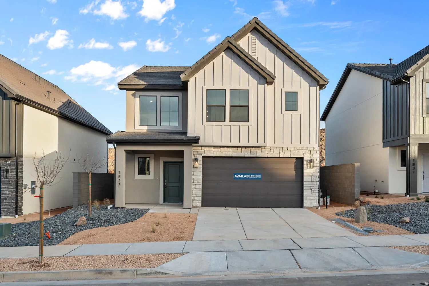 Contemporary exterior with board and batten siding, stone accents, and a dark garage door