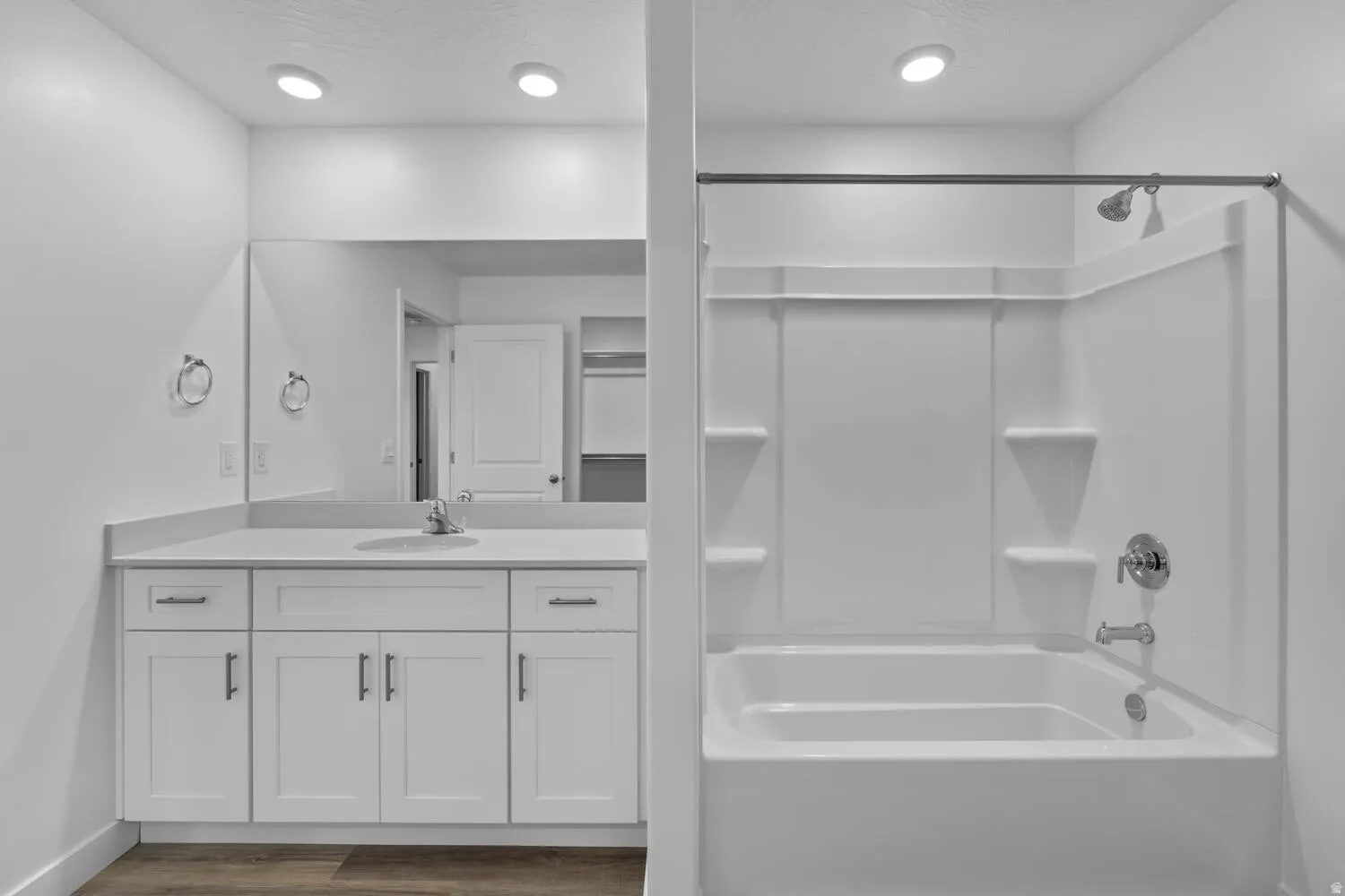 Vanity with white shaker cabinetry, an undermount sink, and a large mirror