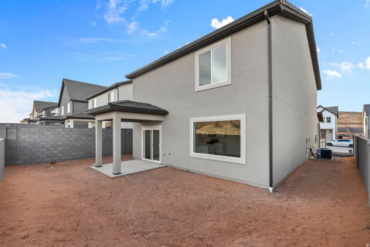 Rear exterior featuring a covered patio with columns and a sliding glass door