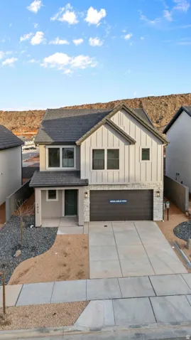 Two-story residence featuring a dark gray shingle roof, a two-car garage, and a concrete driveway