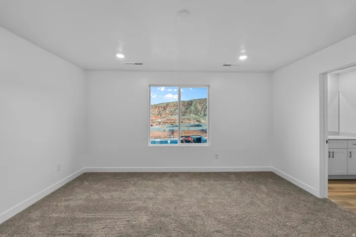 Expansive room featuring recessed lighting, a large window, neutral carpeting, and white walls