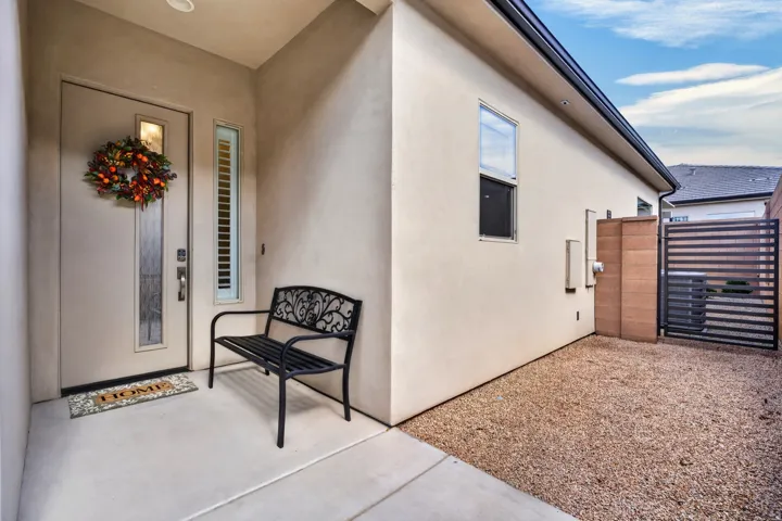 Smooth stucco exterior with dark-framed windows, a glass-paneled entry door, and a matching sidelight