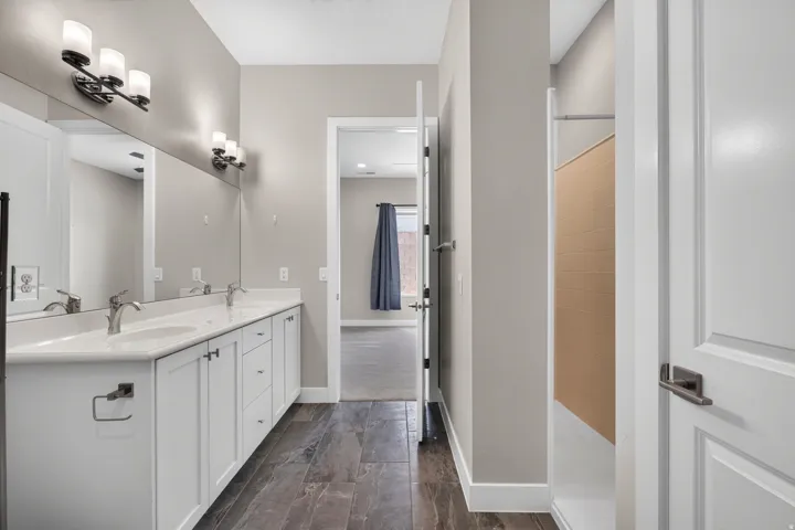 Long dual vanity with white cabinetry, dual undermount sinks, and chrome faucets