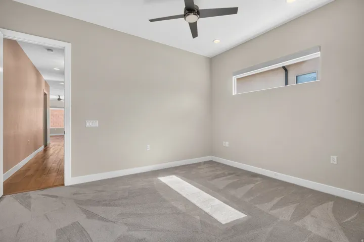 Room featuring neutral-toned walls, recessed lighting, a modern ceiling fan, and a high horizontal window