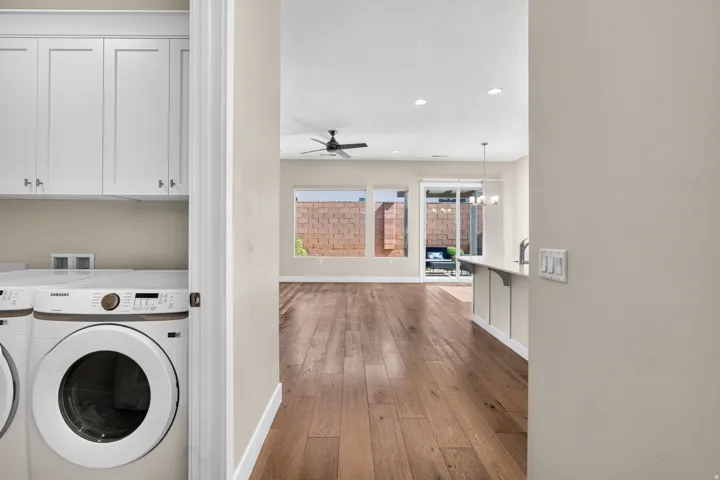 Wood-finish flooring, recessed lighting, and a ceiling fan in the main living space