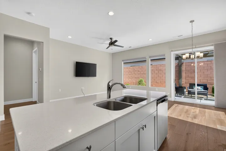 Kitchen island with dual stainless steel sinks, light countertops, and light cabinetry