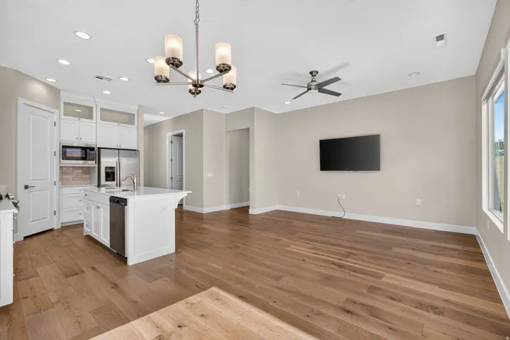 Open-concept living area featuring wood-finish flooring, recessed lighting, and a modern ceiling fan