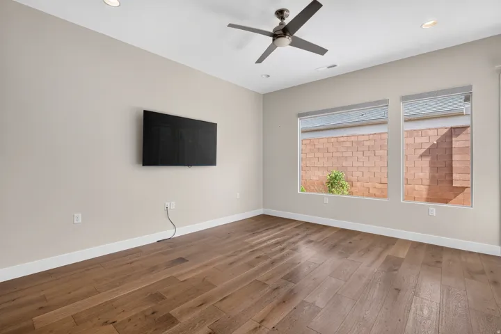 Wood-finish flooring, recessed lighting, and a ceiling fan with light fixture