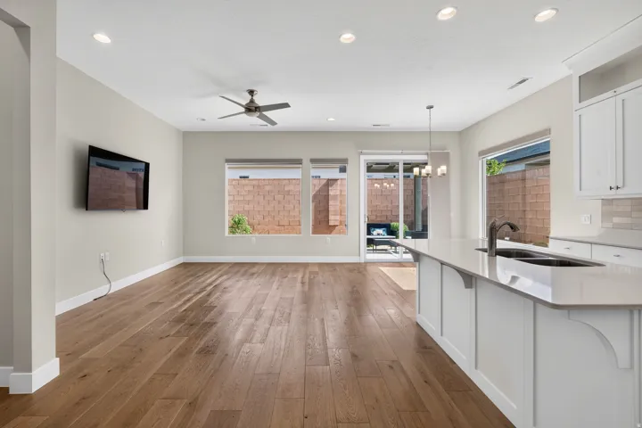 Open-concept living area with wood-finish flooring, recessed lighting, and a ceiling fan