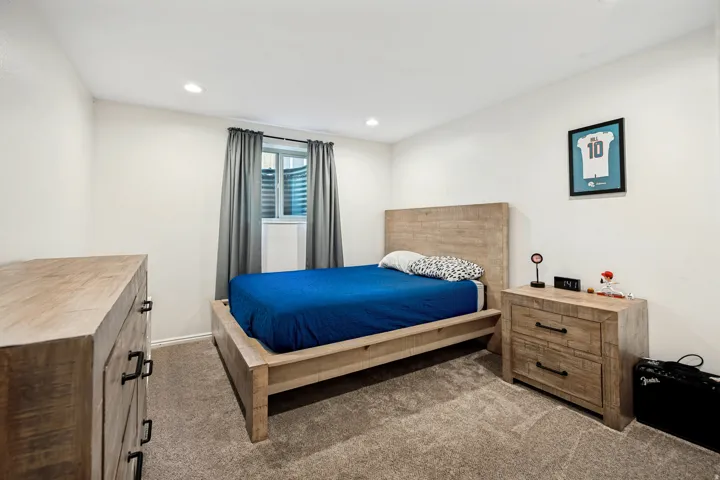 Recessed lighting, light neutral wall color, window with privacy blinds, and neutral carpet flooring