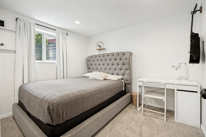 Recessed lighting, window with white trim, wall-mounted shelving, and carpeted flooring