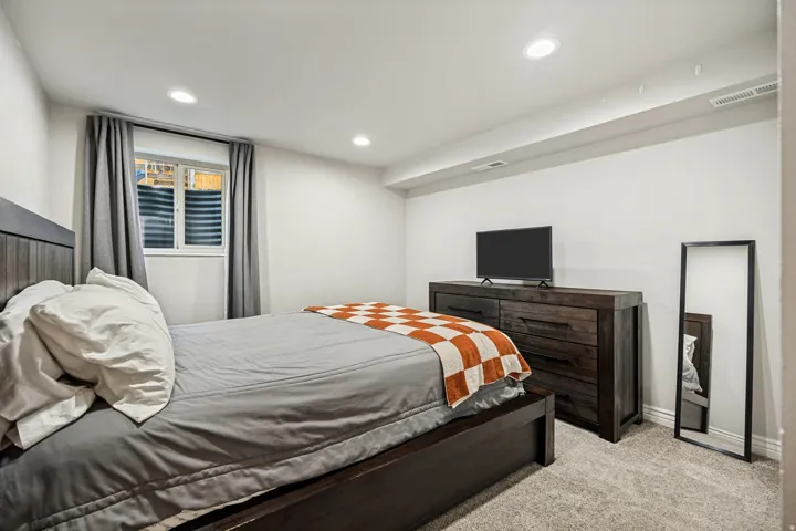 Recessed ceiling lighting, light gray carpeting, and a window with blinds