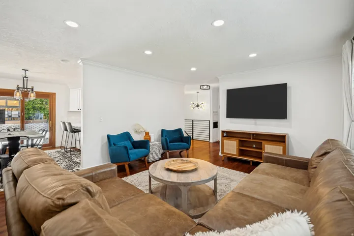 Bright living area featuring recessed lighting, hardwood flooring, and crown molding