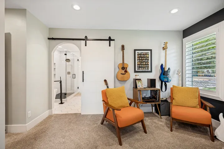 Barn door entry, recessed lighting, window with plantation shutters, arched doorway, carpeted flooring