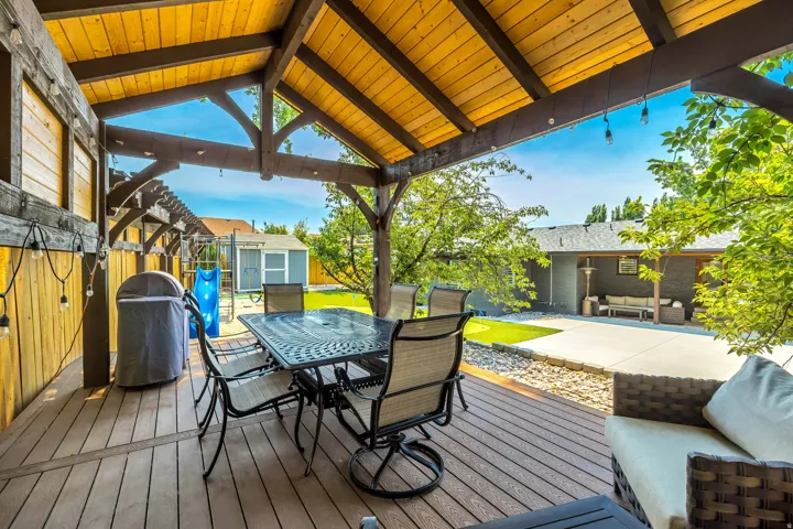 Expansive covered deck with exposed wood beam ceiling, composite decking, and wood privacy fencing