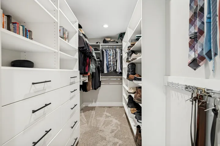Custom closet system featuring built-in shelving, integrated drawers with dark hardware, and hanging rods
