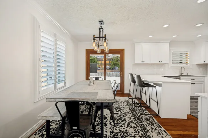 White kitchen cabinetry with a peninsula island, integrated sink, and white countertop