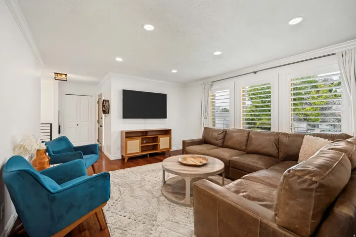 Recessed lighting, crown molding, wood-finish flooring, white plantation shutters, and bi-fold closet doors
