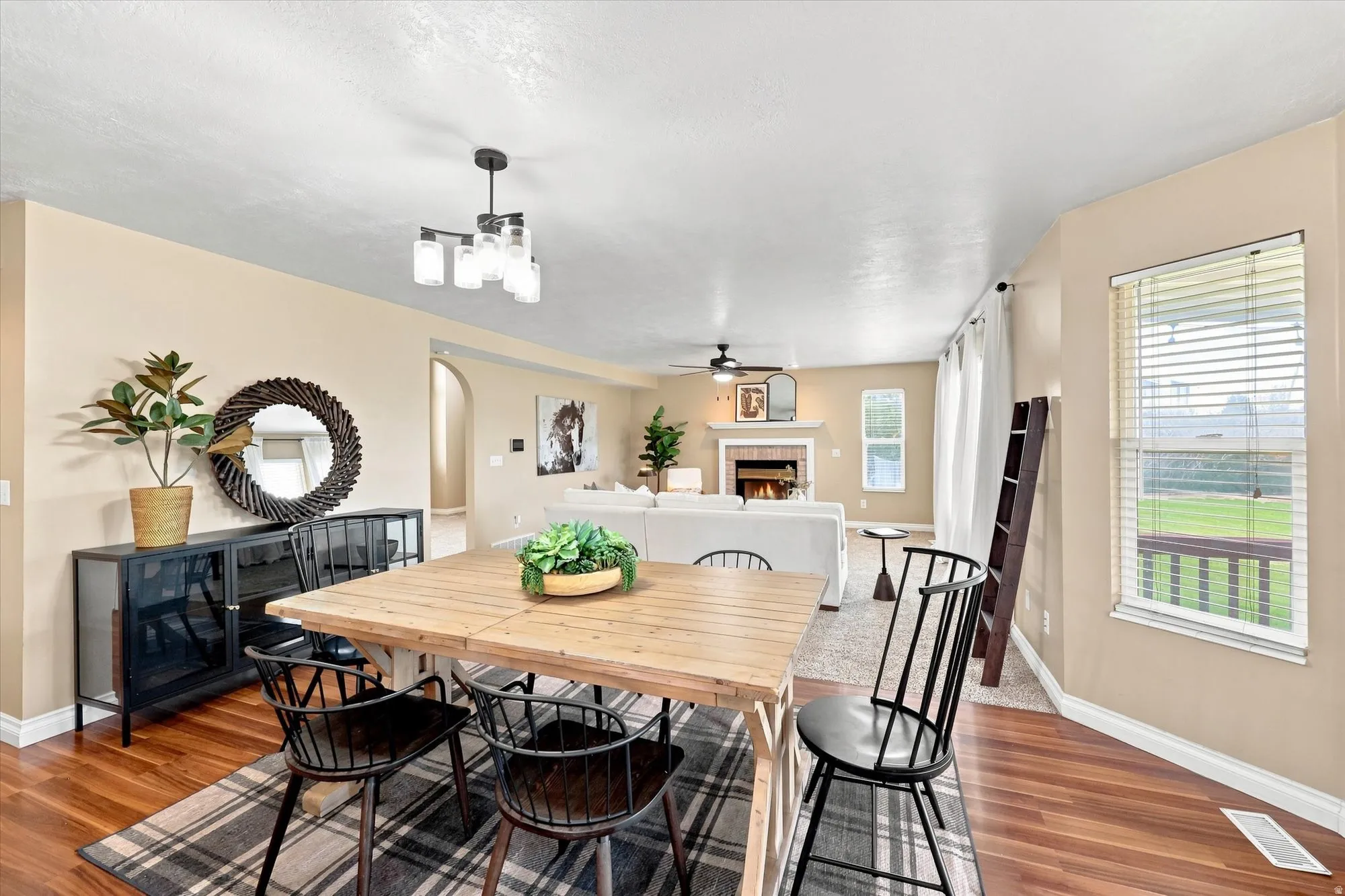 Wood-finish flooring with a modern multi-light chandelier and arched entryway