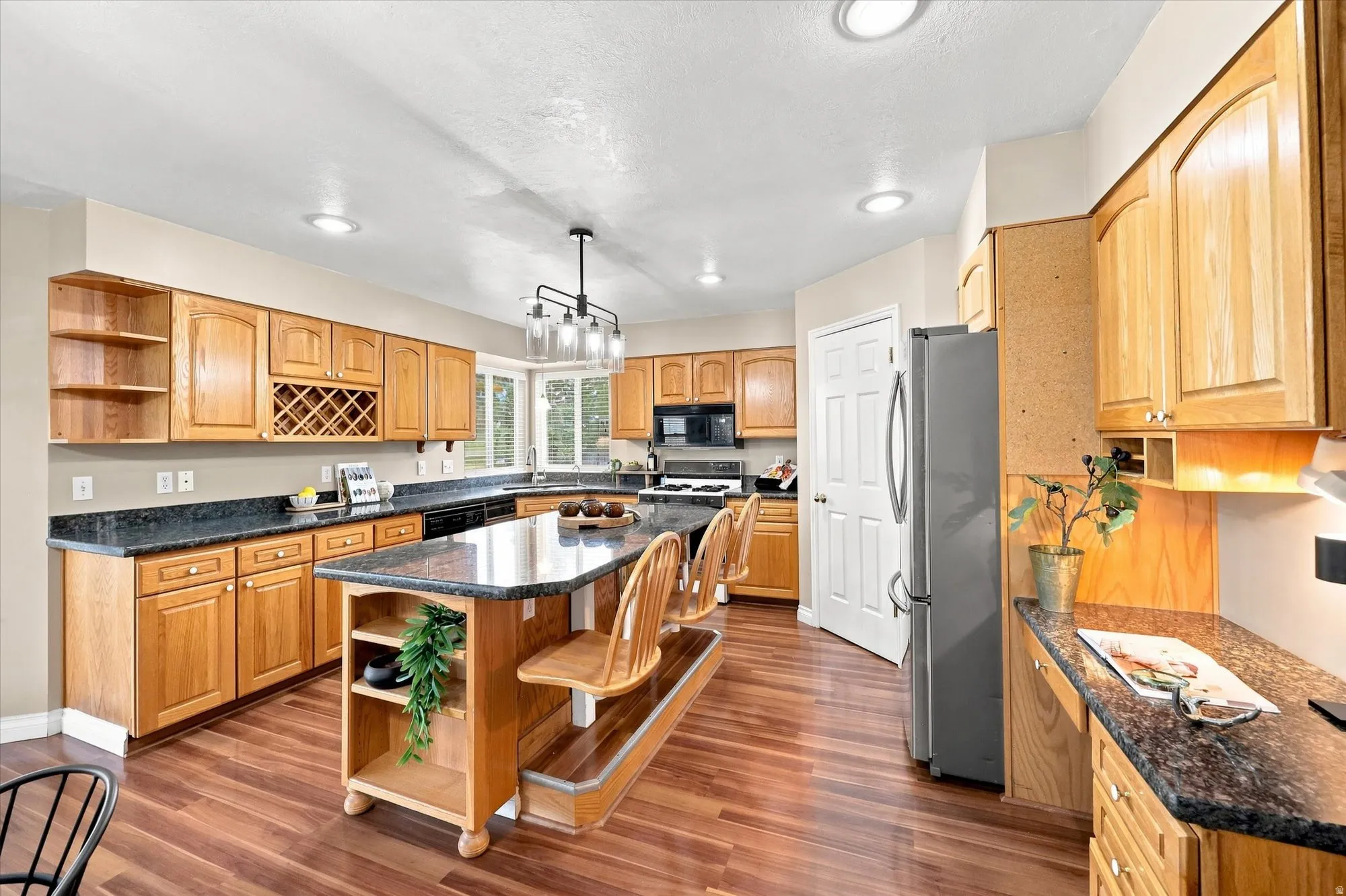 Kitchen featuring wood-finish flooring, recessed lighting, and a large island with built-in seating