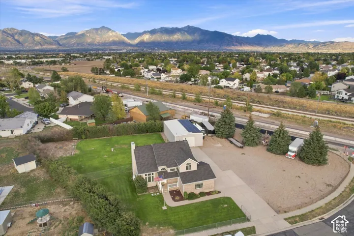 Expansive lot featuring a substantial gravel parking area, mature evergreen trees, and a two-story residence with a gabled roof