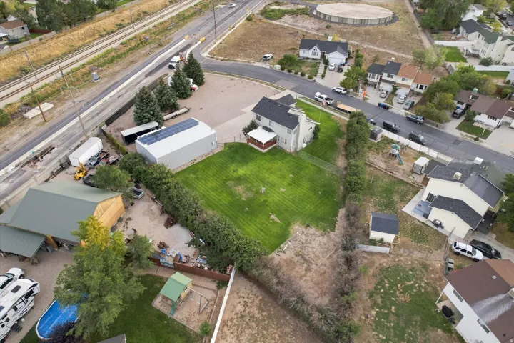 Two-story residence with a covered porch, an expansive lawn, and mature perimeter landscaping