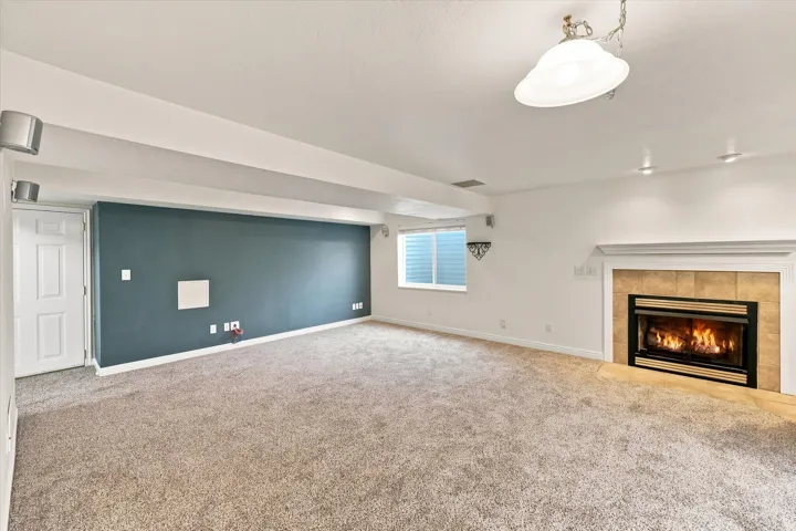 Recessed lighting, ceiling-mounted light fixture, fireplace with tile surround, white mantel, and carpeted flooring