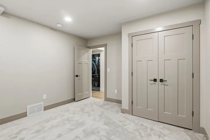 Plush carpeting throughout, recessed ceiling lighting, and panel interior doors with matte black hardware