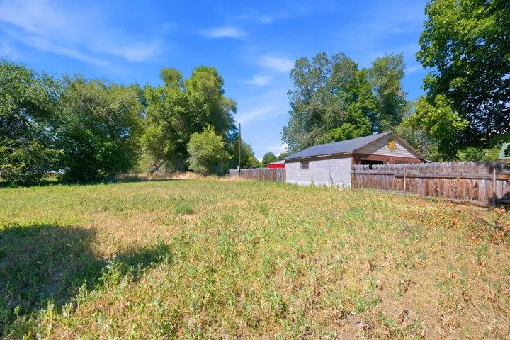 Expansive lot featuring a detached outbuilding with a wood fence