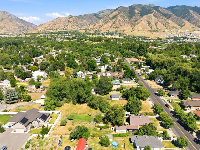 Expansive green spaces with surrounding residential properties, mature trees, and mountainous terrain
