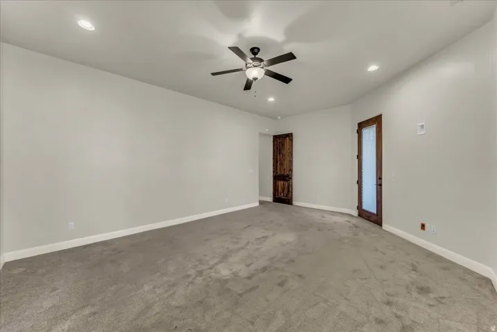 Neutral-toned walls with recessed lighting, ceiling fan, and carpeted flooring