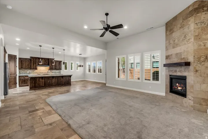 Kitchen featuring dark wood cabinetry, a central island with pendant lighting, and a backsplash