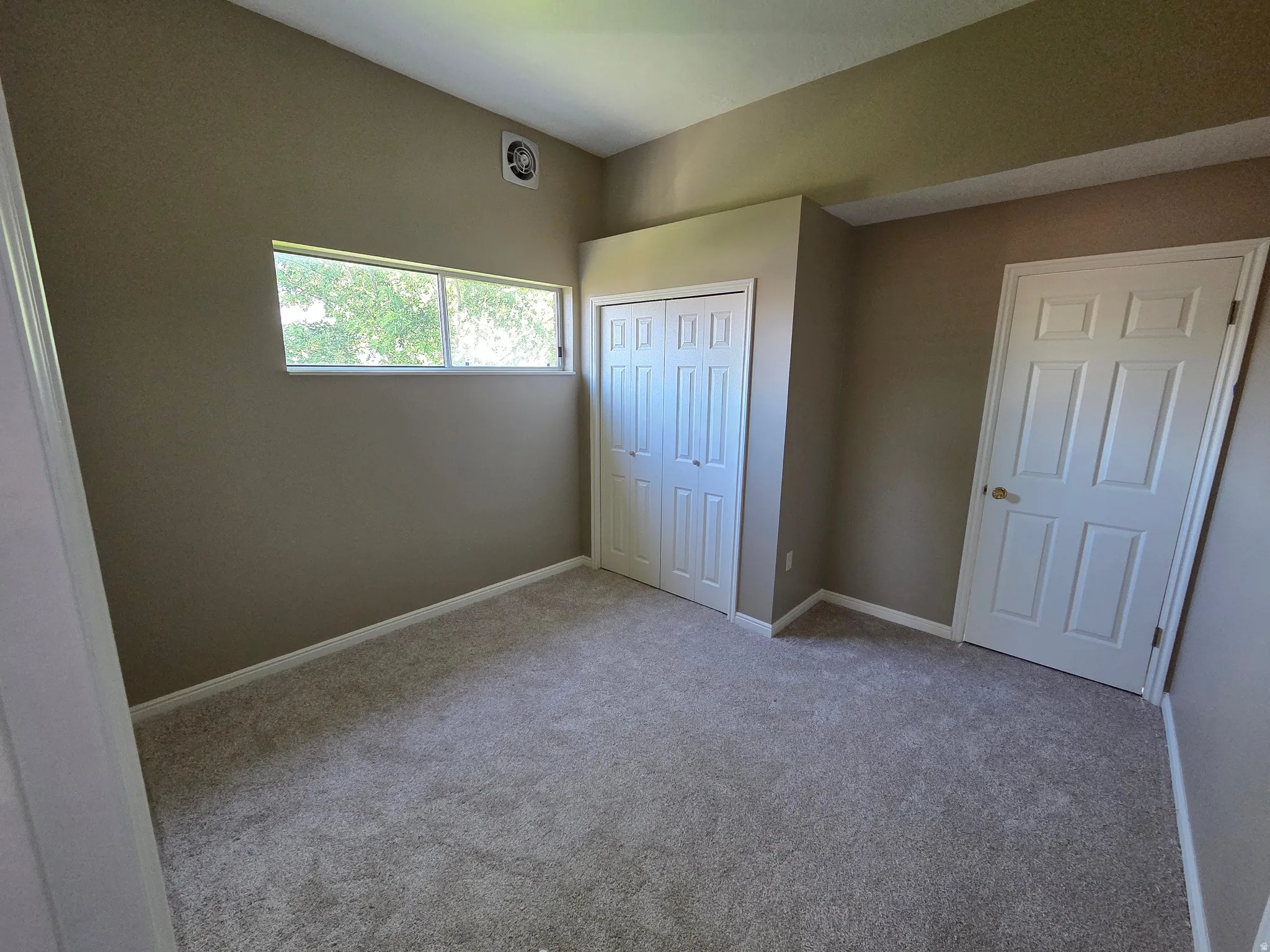 Wall-to-wall carpeting, dual-pane window, and a built-in closet with bi-fold doors
