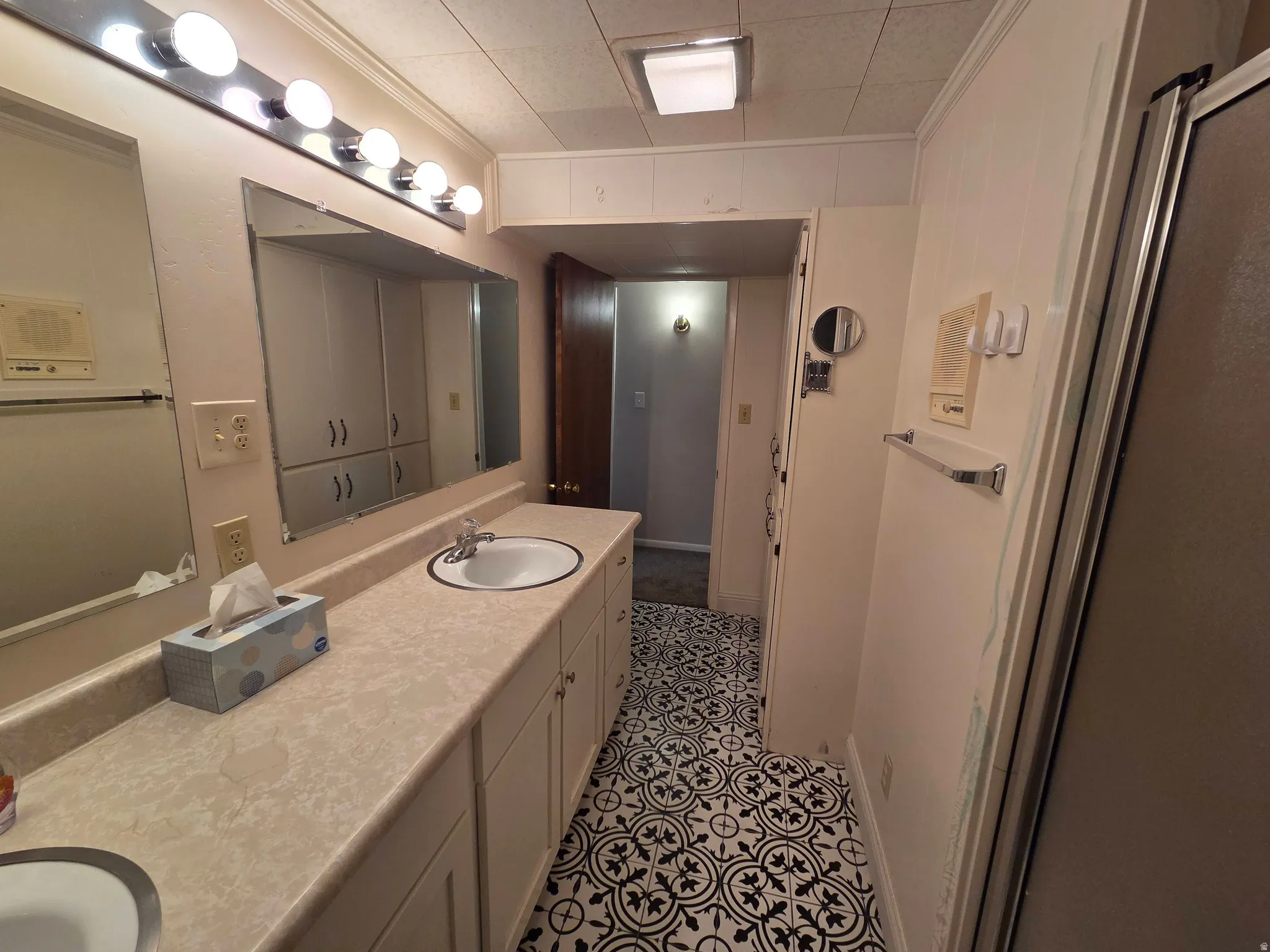Double vanity with integrated sinks, patterned floor tile, and built-in cabinetry