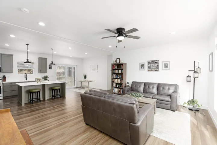 Open-concept living area featuring wood-finish flooring, recessed lighting, and a ceiling fan