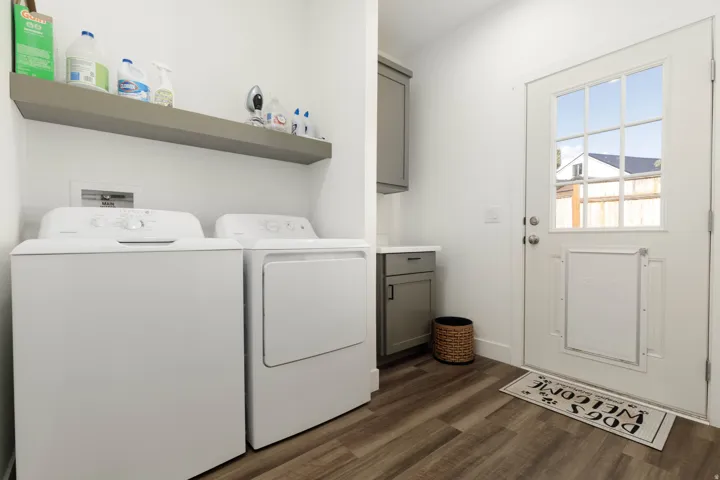 Utility space with wood-finish flooring, a floating shelf, and built-in cabinetry with a white countertop