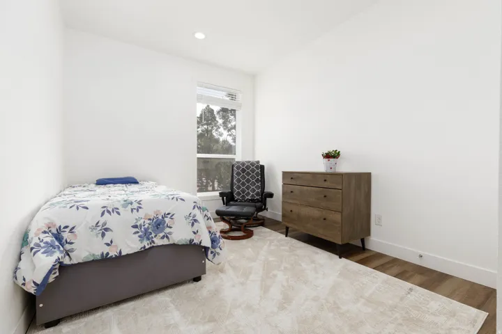Recessed lighting, wood-finish flooring, and a single window with blinds