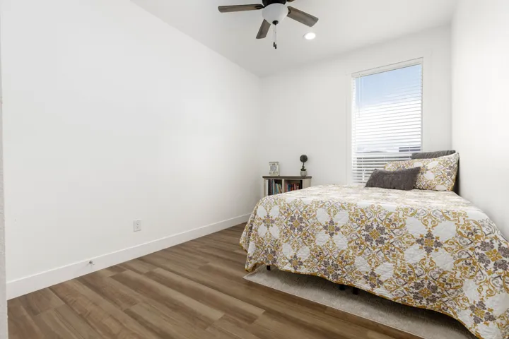 Wood-finish flooring, recessed lighting, ceiling fan, and window with blinds
