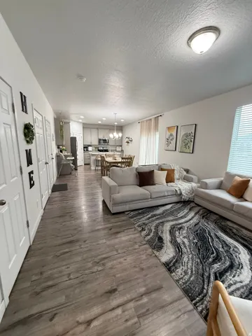 Open-concept living area featuring wood-finish flooring, recessed lighting, and a kitchen with light cabinetry