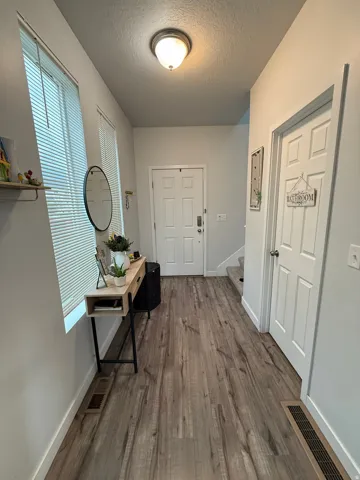 Entryway featuring wood-finish flooring, white walls, and a prominent window