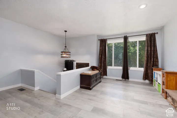 Wood-finish flooring, recessed lighting, and a contemporary hanging light fixture
