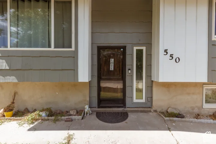 Fiber cement siding with large address numbers, a dark wood-finish entry door